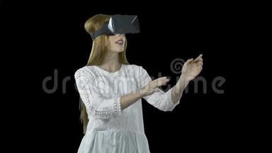 一个戴着3D眼镜的红头发的年轻女孩在虚拟现实中，她翻过一些东西，然后通过举起来创造奇迹